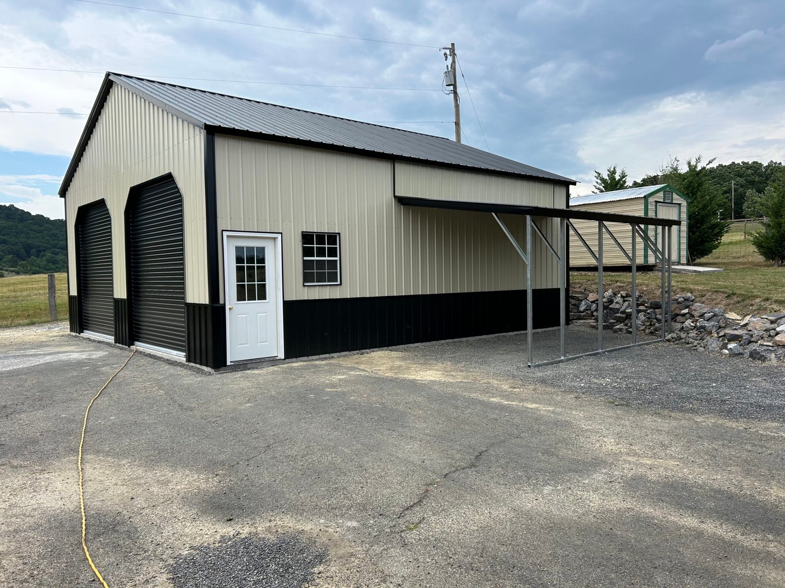 A two-door garage with a black roof, showcasing a simple architectural design where just a retaining wall is used.